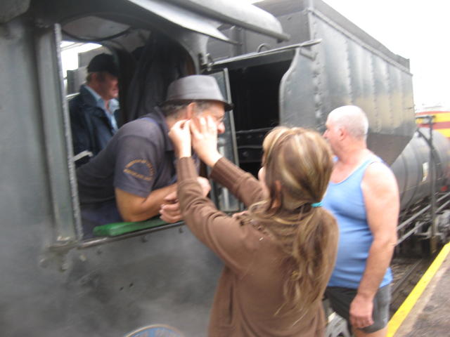 Nathan's daughter does something to his ear, while coach-restorer Pekinese looks away