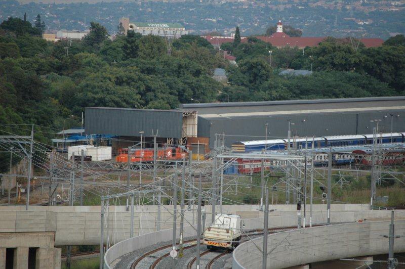 Telephoto view of the TFR Blue Train shed and shunt diesels. The foreground track on the right is Gautrain from the Hatfield area and the other is the Johannesburg link. Note the road/rail truck for Gautrain works.