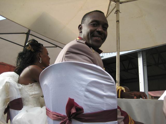 The groom turns round to talk to a bloke in dirty overalls