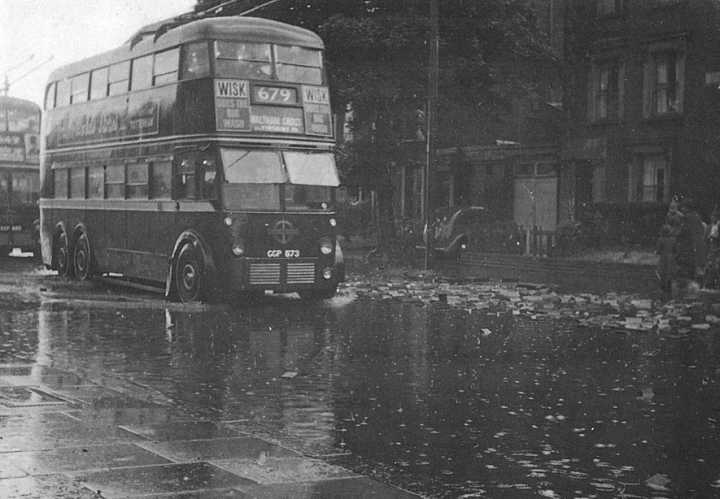 A 679 trolleybus negotiating a flooded Fore Street in 1949 with the wooden road blocks floating to the surface