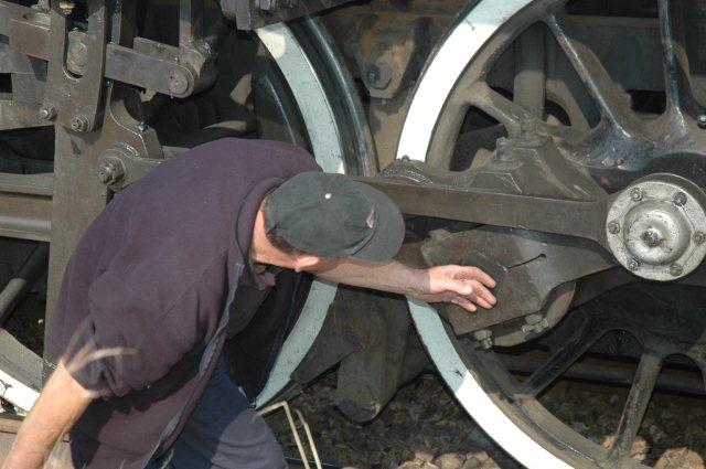 Driver Frik Boshoff uses the time for the signal change to inspect the locomotive.