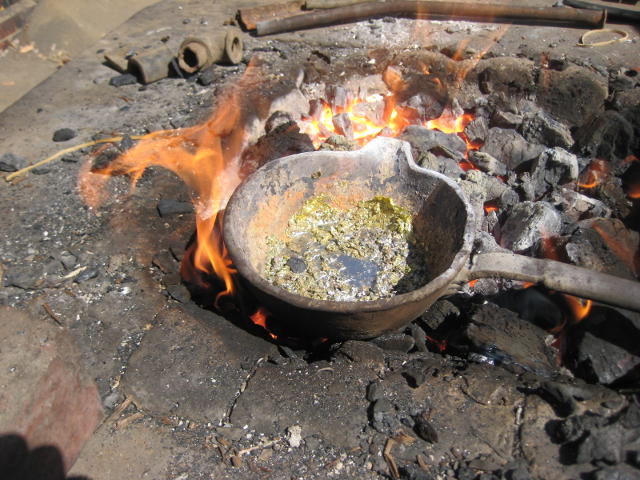 The molten alloy simmers on the hot fire