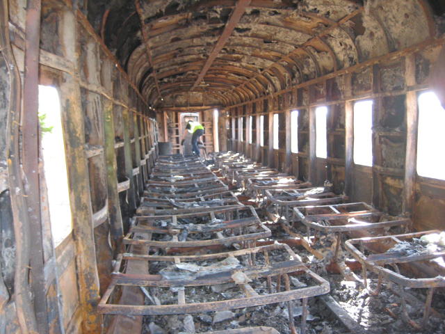 Nathan scrambles through the burnt-out interior of the sitter coach
