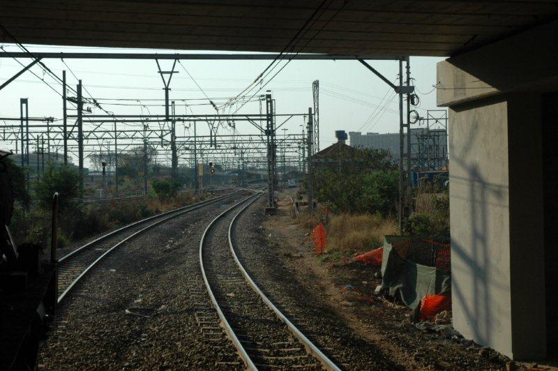 Under the bridge approaching Pretoria, the yellow light of the signal calls the train on.
