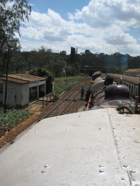 The signalwoman stands ready with the token as we approach the Uganda end of the marshalling yard, with the Mombasa Road bridge ahead