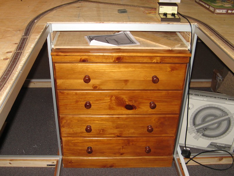 The center of the inverted "U" holds a chest of drawers - both for storage and support.