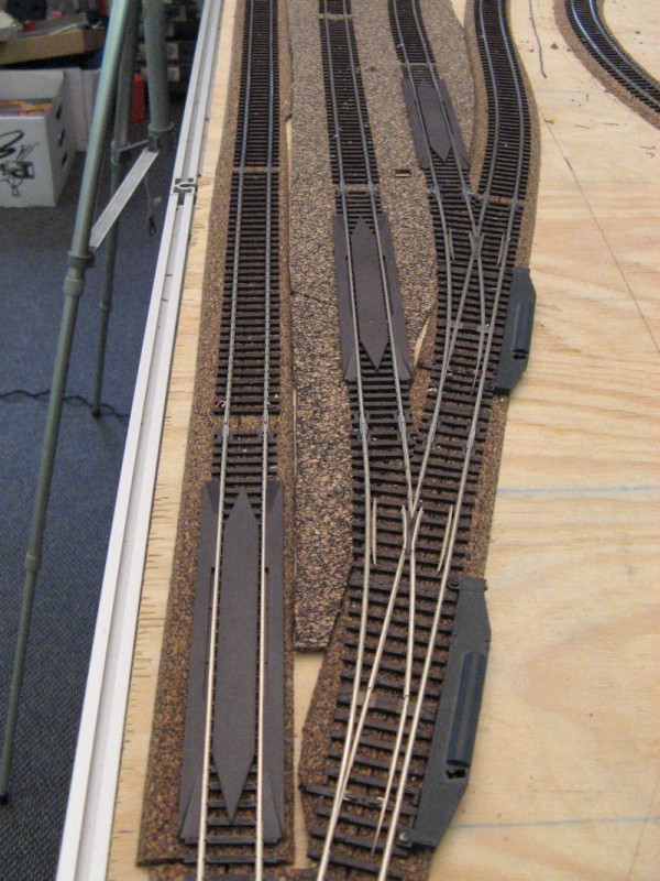 Close up of the re-railers. Since the track work is &quot;hidden&quot; reliability is required, so after every trailing point where the track work is covered, re-railers have been placed.