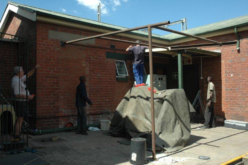 Steve Smith assisted by Tom, Raymond and Welcome, as he constructs the shed roof to protect the diesel generator. Now we know why the hoarding of material is so important!