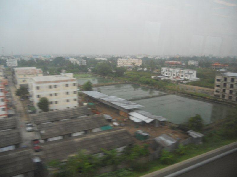At speed from the train. Muggy Bangkok  approaches. It is still early and the city sleeps.