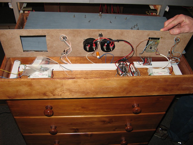 The front of the panel lifted to shown the wiring directly under the train controls.