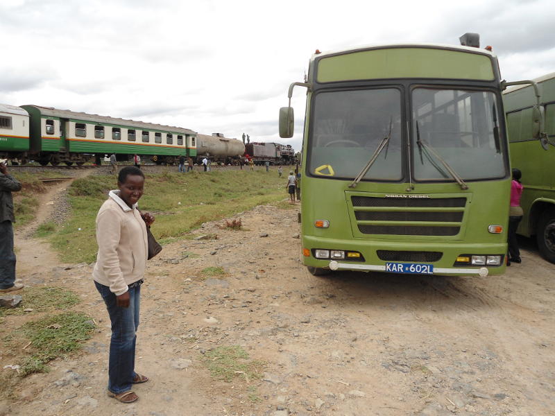 Jane stands in front of a KWS bus with the train in the background