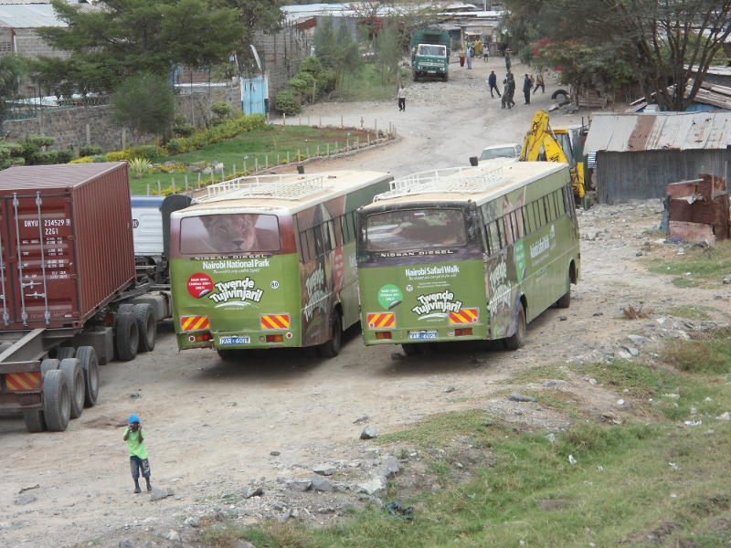 Kenya Wildlife Service buses wait for us at a small lineside shopping centre just before Athi River bridge