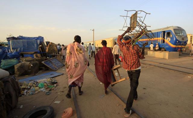 Southern Sudanese people carry their luggage to a train before travelling to South Sudan, in Khartoum. (Reuters)