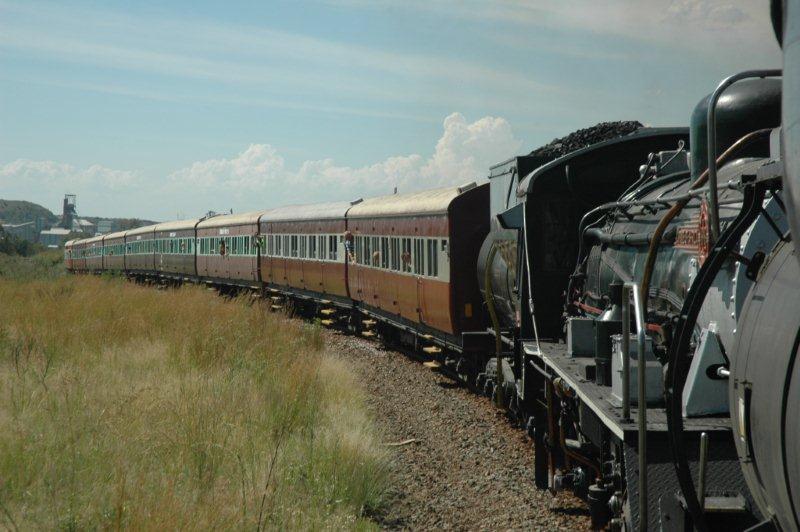 Viewed from the footplate of the class 24, the winding tower headgear for the diamond mine at Cullinan can be clearly seen in the background, as the double header lifts the load out Cullinan back to Pretoria.