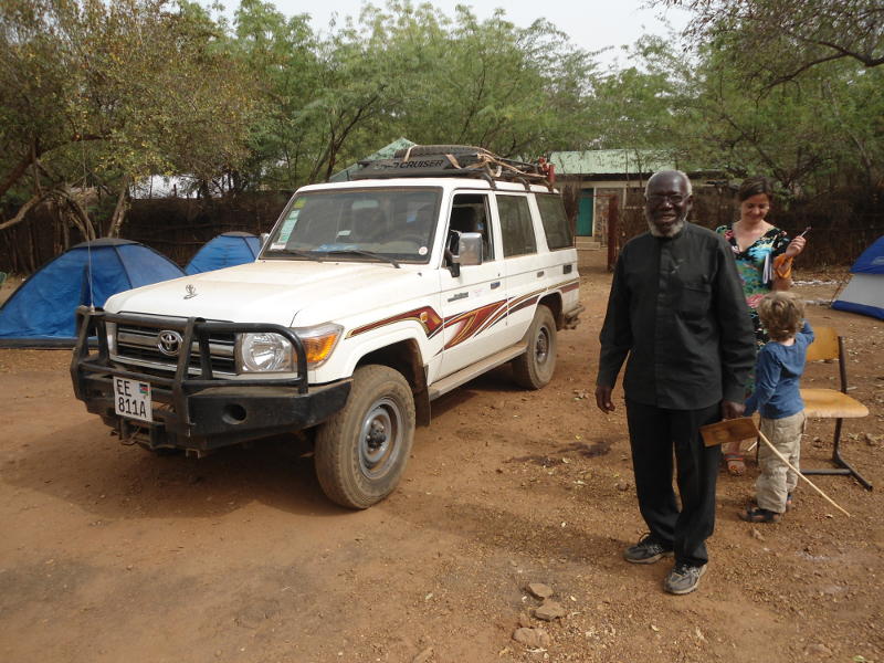Bishop Paride Taban stands next to a type of Land Cruiser which is quite popular in South Sudan, particularly for carrying people in less extreme climatic and terrain conditions.