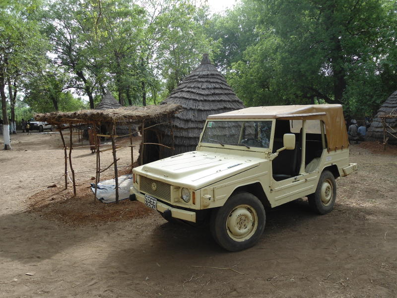 The VW stands next to the simple, door-less thatch house where the bishop slept, having given up his own house for guests