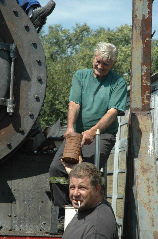 John has difficulty lifting this heavy tin from Gabor, who takes such lightweights in his stride!