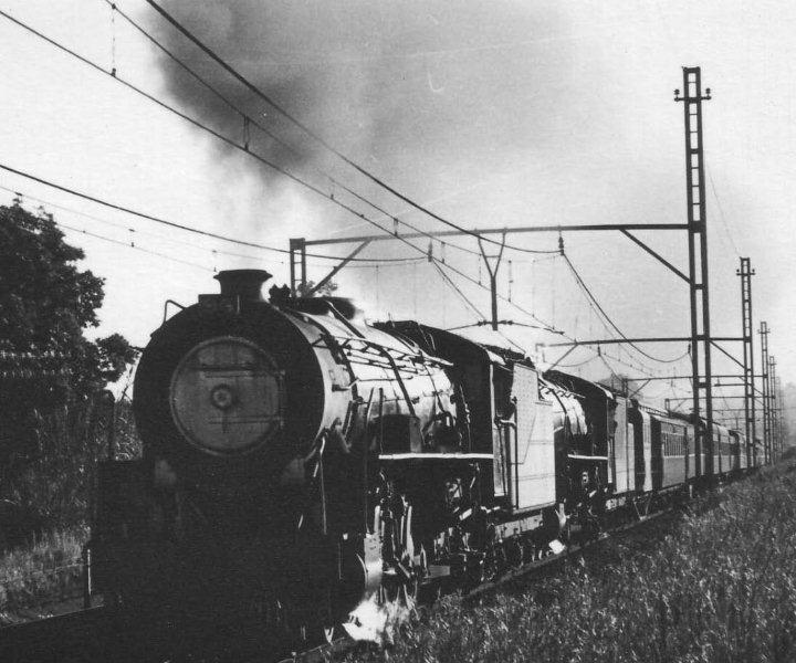 While sitting on my bicycle before school started, I would do homework by the lineside at Loftus Verseveld station and watch the passing steam parade. There was firstly the Komati passenger usually double header Witbank 15CAs, followed by the L.M. Mail with either a GMAM or double 15CA and finally a single 15CA on the Cullinan train. Here we have 2054 and 2077 on the Komati pass towards Pretoria. The Gautrain line is now where I took the photo. 23 November 1971