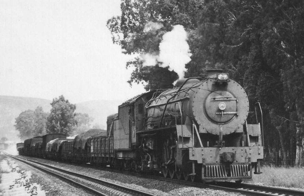 Prior to electrification, the line past Pretoria North was pole free and in the early 1970s was still busy with steam hauled trains. They ran to Pietersburg or even wayside shunts to Warmbaths or Nylstroom. Seen exiting from the road bridge at the North end of Pretoria North station is 15CA number 2819 heading North. 1971
