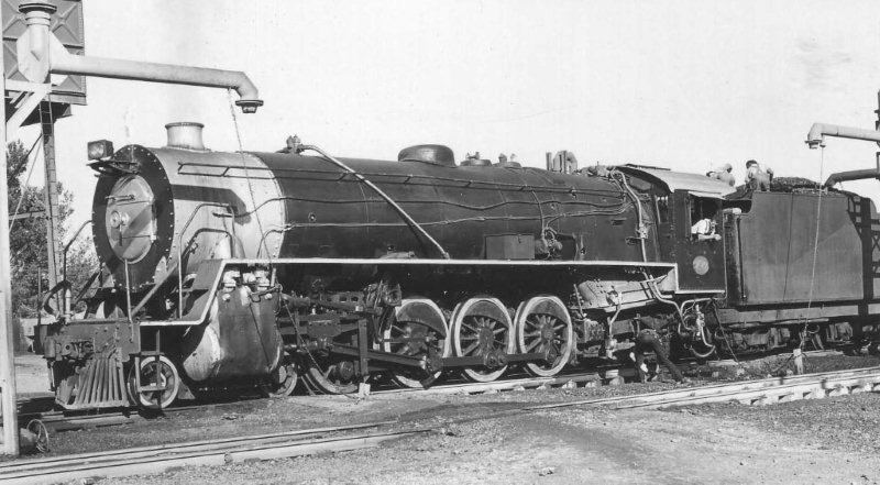 Bronkhorstpruit was the half way point between Capital Park and Witbank. The locomotives would clean fire and take water, with 12 minutes being allotted to this task. The columns were swing over trunk types, requiring the Fireman to first get hold of the  gantry chain, climb up on the tender and then swing over the gantry arm, climb down and turn on the water valve, get back in the cab, clean fire and then remember to turn off the water! Note the coal trimmers.