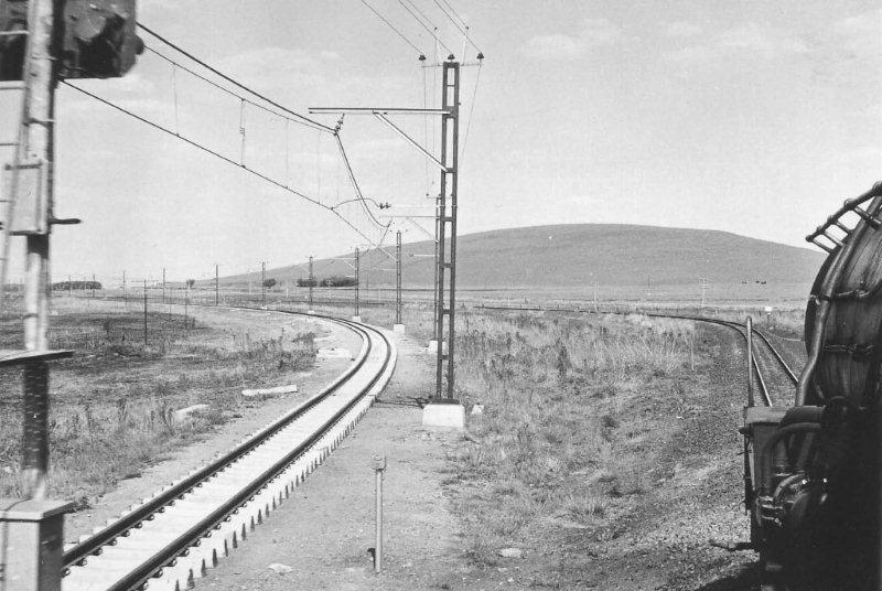 During the early to mid 1970s, there was much work on the Eastern line especially from Witbank to Eerstefabrieke, with electrification and track alignment. The poor electrics had to have better alignments from steam, so there were many sections where curves and gradients were taken out. Here we pass on the old formation near Wakefield where later in the day we would return on the new track. The 15CA we were in was on a goods to Pretoria from Witbank. 1975