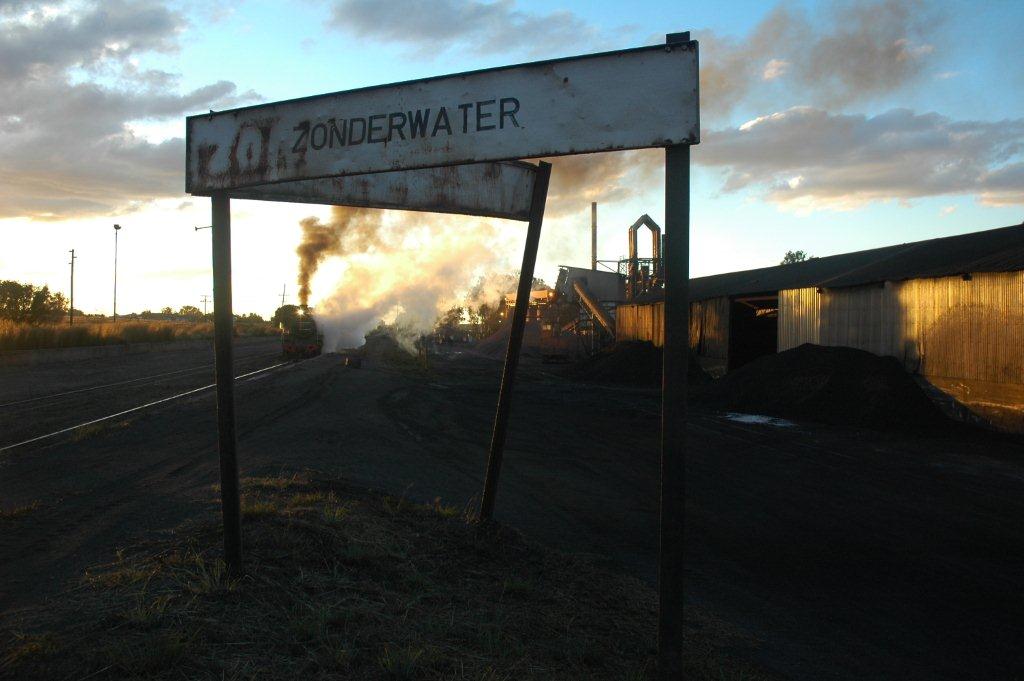Journeys end. The branch line locomotive stands with its mixed train having just arrived from Cullinan with the daily mixed. The huge works and setting sun make for a dramatic vista.