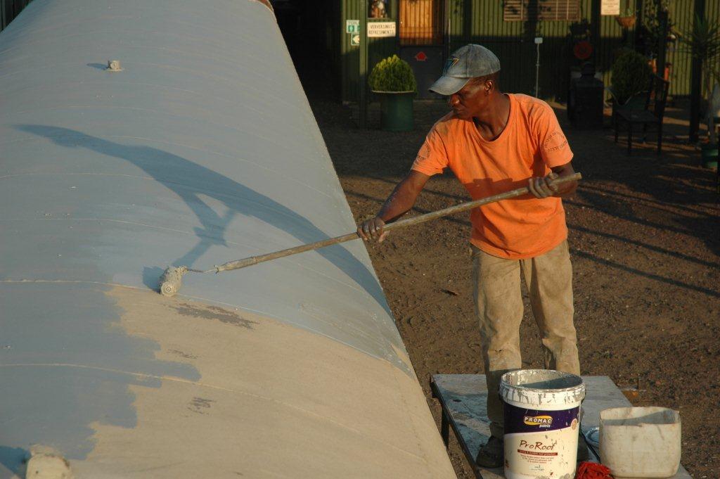 Our man at the site, Chris, applying the donated PROMAC roof paint to our coaches.
