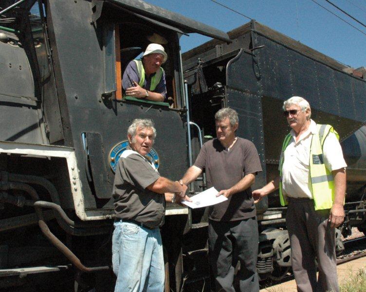 Steve has passed to Coen Pretorius' satisfaction. At Rayton, Steve is handed his certificates by Coen and Cliff Avis, whilst Tony Attwell, the Fireman, looks on from the cab.
