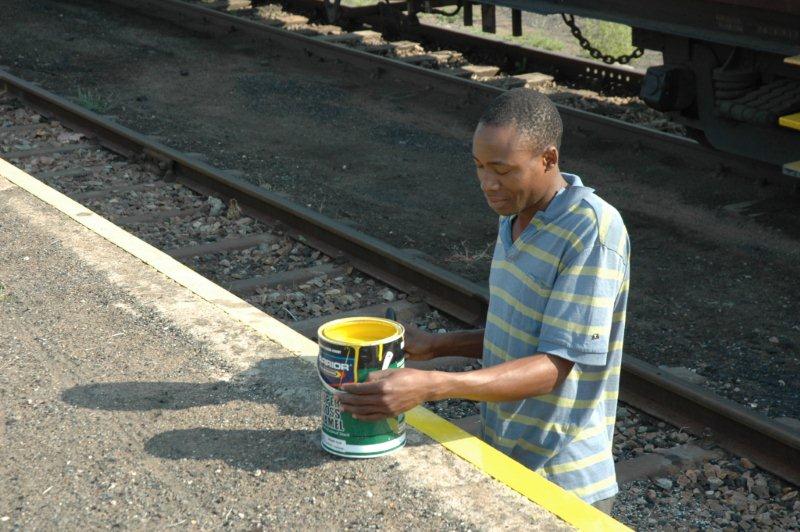Colin at work tidying up the rail edge with yellow paint whilst simultaneously filling the coaches with water for the next trip