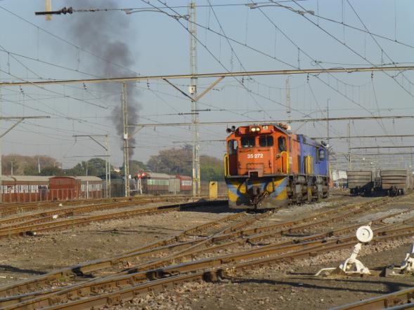 The Hercules shunt cars idle in the yard with 3360's plume of smoke visible in the background. We have set back out of our depot up to the stop board which marks the interface between FOTR's private siding (Hermanstad) and the TFR yard (Hercules), and we now await the signal to allow us to depart