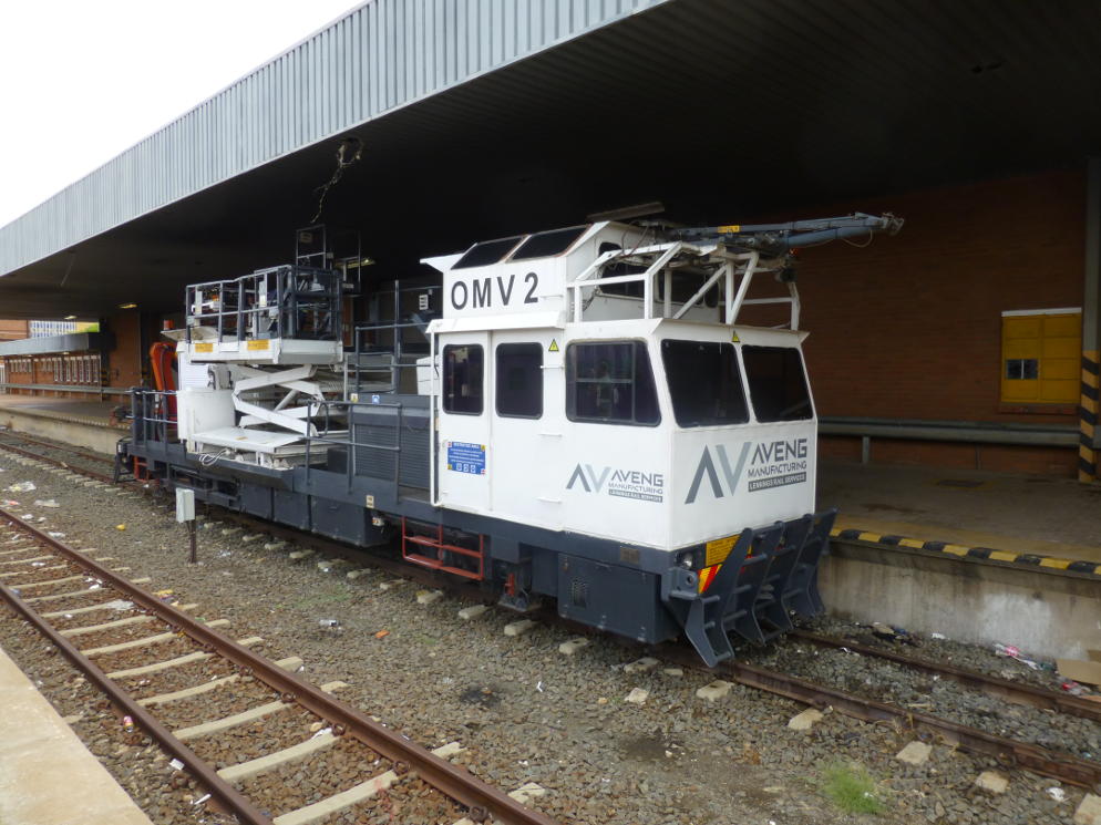 An overhead wire maintenance vehicle stands in the platform.