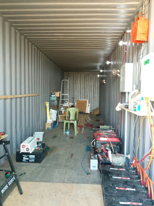 The inside of the empty container. The solar power kit can be seen at the front right. The red back-up generator is due for removal.
