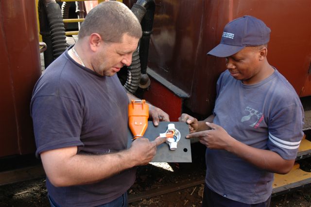Gabor demonstrates to John M the intricacies of the electrical plug in points soon to be fitted to the coaches, as FOTR get into the electric age. The base plates for the plug points were designed and laser cut by Gabor.<br /><br />Photo by Nathan Berelowitz 18/08/