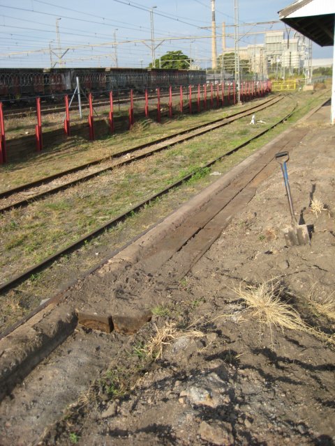 Improving the platform surface. In the mid-distance, fresh paint on the railings, and further away can be seen the newly-painted yellow gate