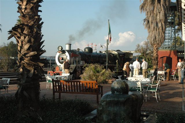 The late afternoon sun falls on the 19D locomotive, whilst a group of passengers, awaiting their chartered train, enjoy the cocktails, and view