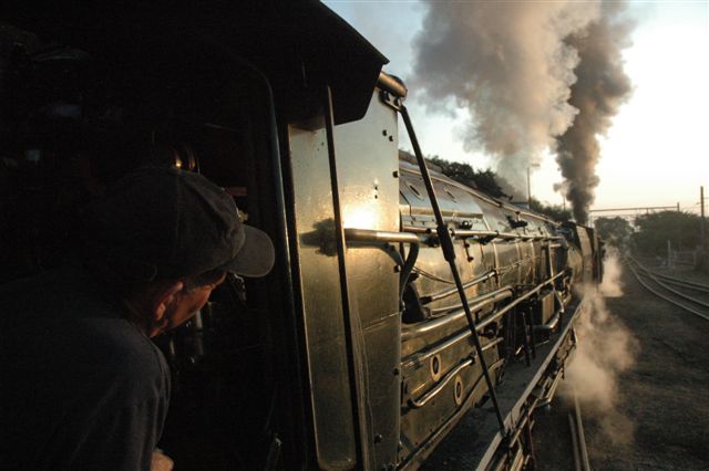 "Right away", and the double header 19D and 25NC combination depart into the proverbial sunset, with a a late Rovos charter train to Mafeking (sic). The steam will work only as far as Centurion station, but is up grade all the way.
