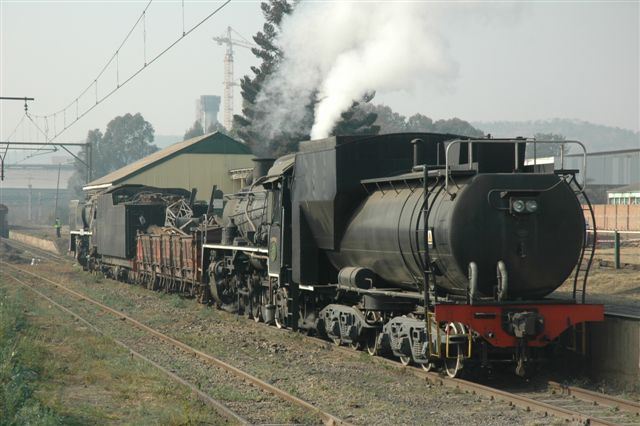 The stubby 24 class pushes her load up the steeeep grades into the new site at Hercules. The 15F was being relocated from Capital Park, and the DZ wagon, filled with spare material, will soon be off-loaded.