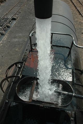 Strongly flows the stream of life. A powerfull column of water gushed into the hungry tender of 2650 as she stands at Cullinan after having had her fire cleaned.