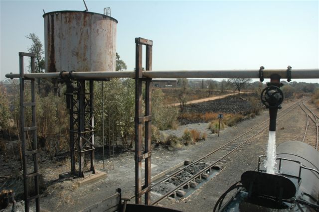 Water, wonderful water. The column at Cullinan has been reinstated once more, and the timeless scene of a locomotive watering can, once again, become reality. For about three years, the water supply was disconnected, and with new ownership of the station, permission was given to repair. The hard work being carried out by Robert Dadford. Viewed from the tender of 19D number 2650.