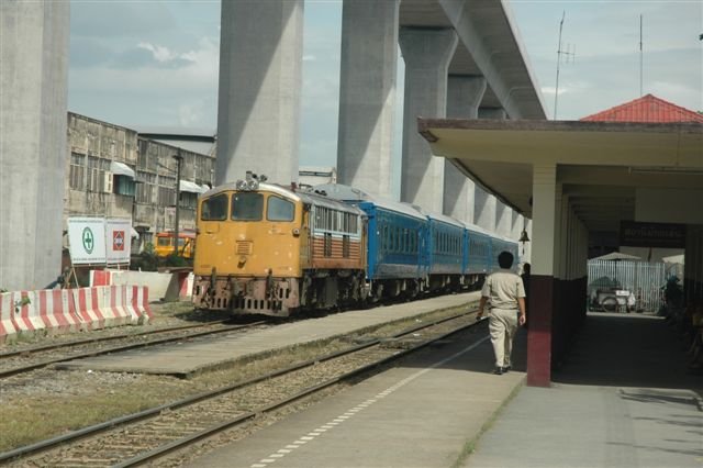 State Railways Thailand (SRT) diesel loco on the shunt at Makassan station. In the background is the railway workshops. The huge concrete pillars, are supports for the airport rail link, expected to open in 2009