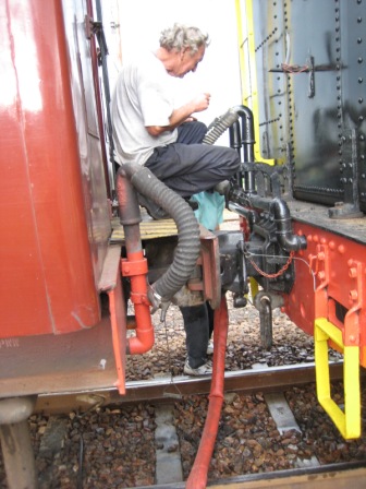 Cliff and Steve make the connection. FOTR locos have a water fitting under the tender as it's not permitted to climb on top of a tender under the overhead electric wire