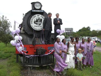 John and Nick pose on the loco while Mary, Betty, Red, Macu and Laura surround Jane and great-nephew Kiran