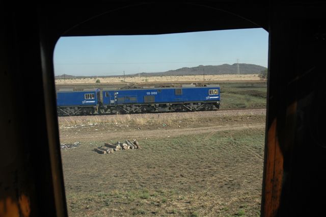 Framed by the cab window of 2650, a brace of 10E locos bring in a block load to Pyramid South, from Sentrarand