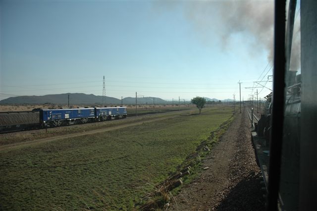 Steam looks down on modern traction or does the modern traction look up to steam? Two class 10E electrics trundle into the yard at Pyramid South with a block load from Sentrarand, whilst the 19D on the Tswhane Explorer approaches the signal, after having run around the balloon