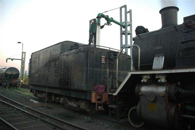 Early morniong and the locomotives' tenders must be filled prior to going out on shift. OOPS! This one seems to have lost the loco?! Spikkels fills the tender of a 15CA prior to it being taken to the new site at Hermanstad. Unfortunately the drain plugs had been removed and all it got was a rinse!