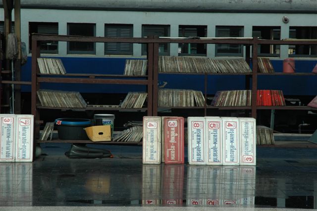 Carriage destination boards reflect off the wet platform at Bangkok station.
